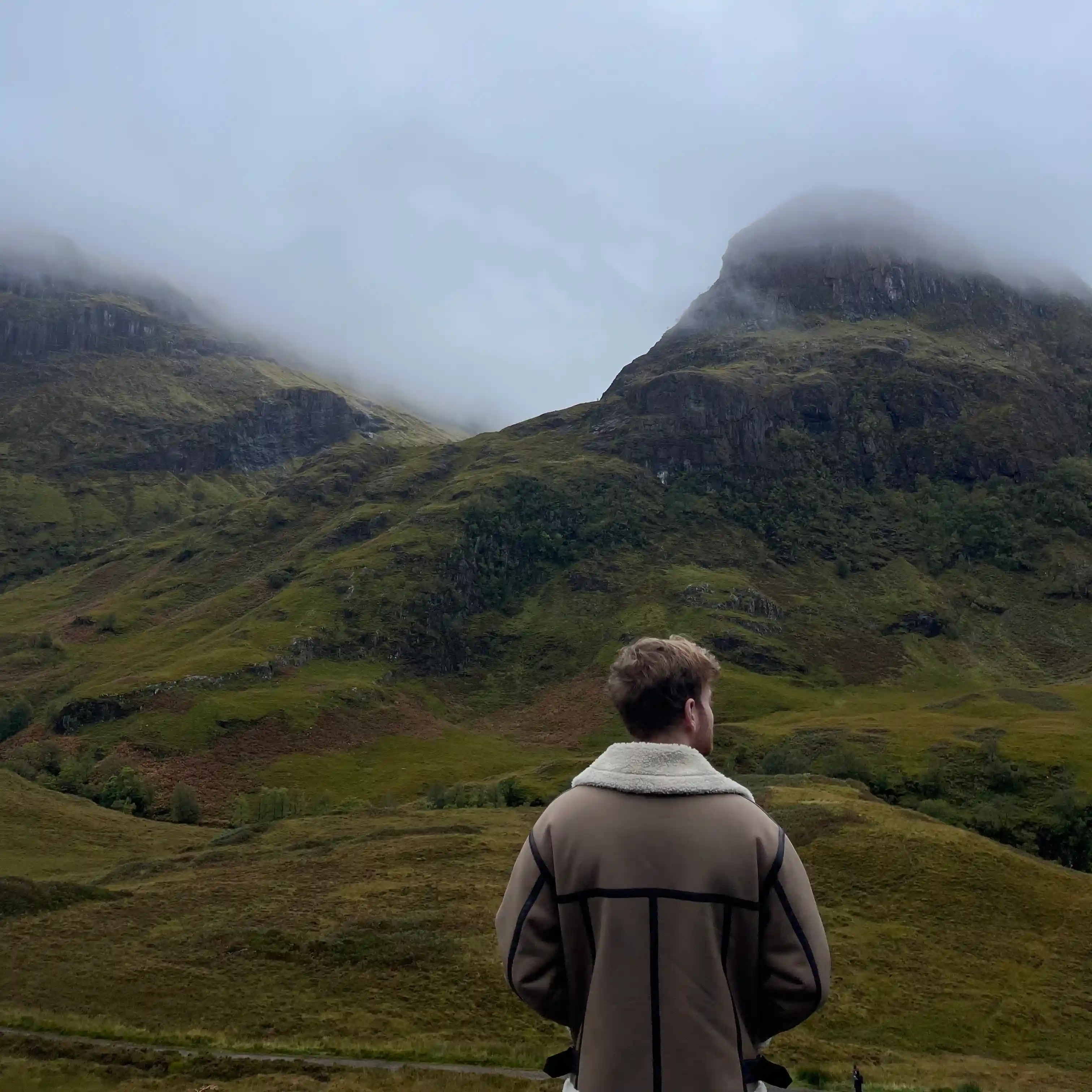 Person looking out at misty Scottish Highlands